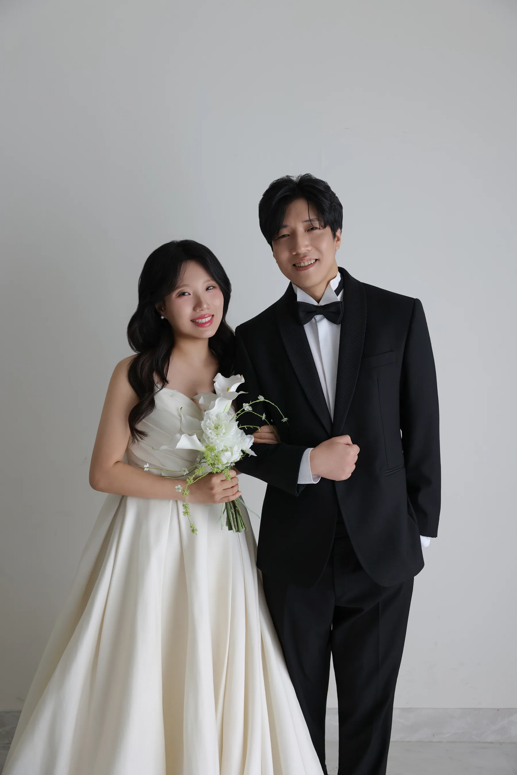밝은 회색 배경 앞에서 미소 짓는 박시현 이예지 커플